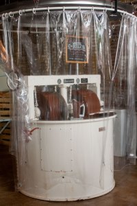 A machine processes cacao beans into chocolate liquor